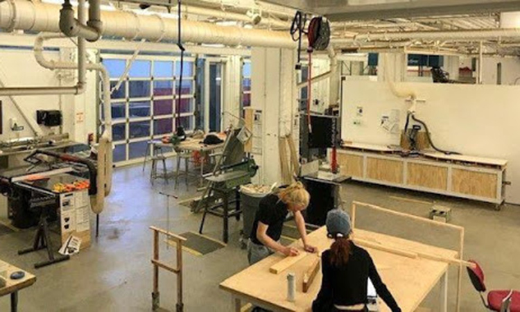 Students working at a table in the Sculpture woodshop